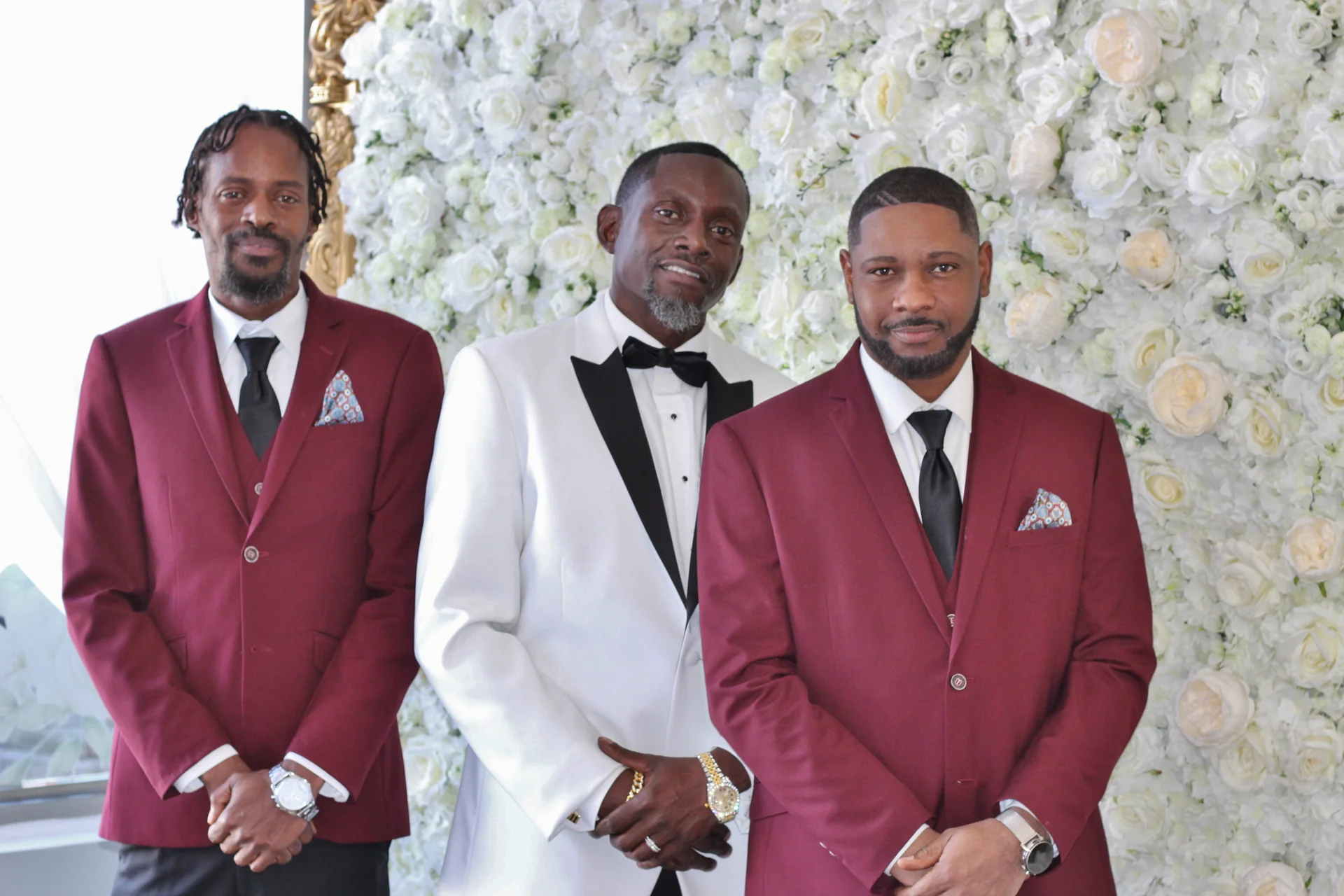 Groom and groomsmen at the flower wall